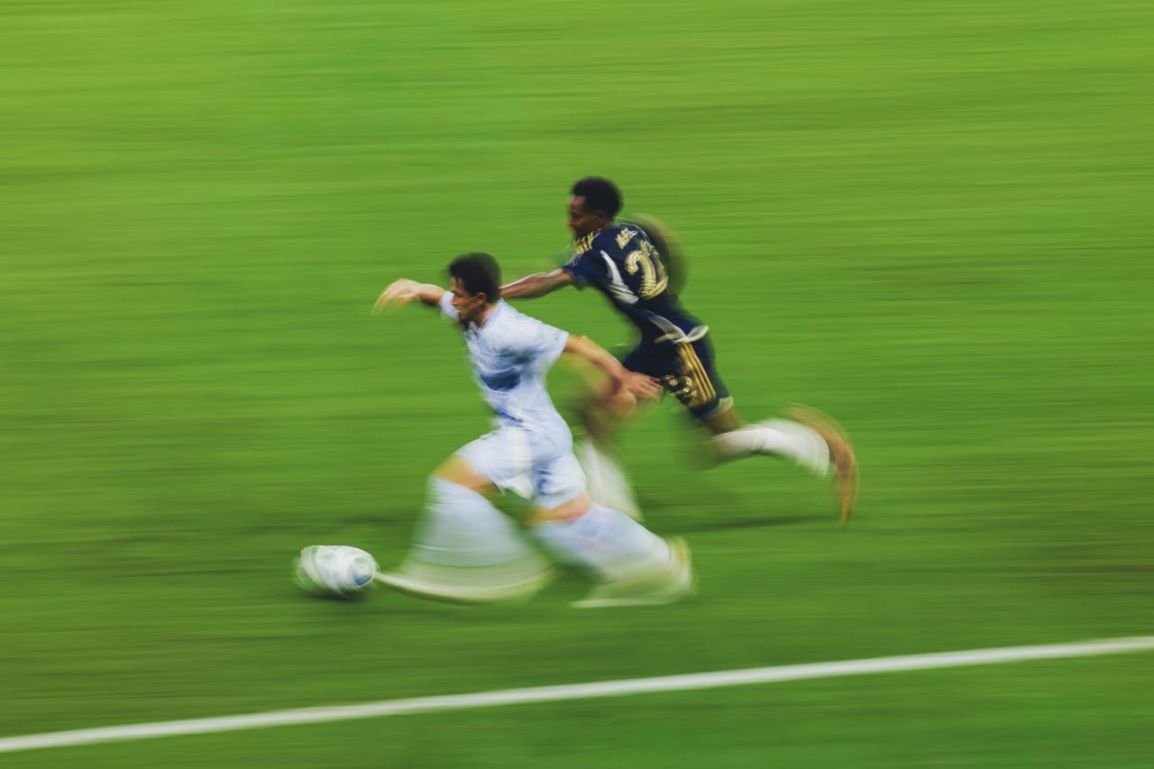 Sporting KC midfielder Manu Garcia holds off a Vancouver defender.